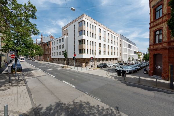 Große Kreuzung in Wiesbaden mit modernem Mehrfamiliengebäuden im Hintergrund.